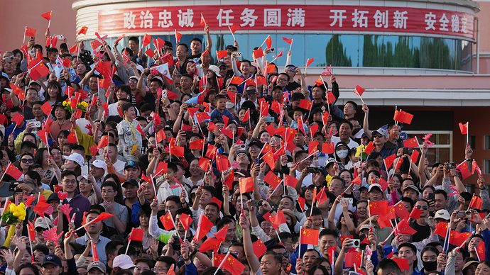 2026年5月24日,酒泉卫星发射中心,人们挥舞着国旗为神舟二十三号载人航天任务航天员送行。